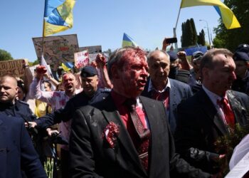 09.05.2022. Warszawa. Ambasador Federacji Rosyjskiej w Polsce Siergiej Andiejew (w środku) oblany czerwoną farbą przez uczestników protestu podczas próby złożenia kwiatów przy Cmentarzu-Mauzoleum Żołnierzy Radzieckich w Warszawie. 9 maja Rosja obchodzi dzień zwycięstwa nad hitlerowskimi Niemcami / PAP/Leszek Szymański