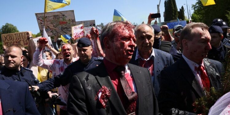 09.05.2022. Warszawa. Ambasador Federacji Rosyjskiej w Polsce Siergiej Andiejew (w środku) oblany czerwoną farbą przez uczestników protestu podczas próby złożenia kwiatów przy Cmentarzu-Mauzoleum Żołnierzy Radzieckich w Warszawie. 9 maja Rosja obchodzi dzień zwycięstwa nad hitlerowskimi Niemcami / PAP/Leszek Szymański