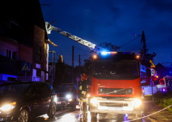 23.07.2022. Kraków. Strażacy zabezpieczają uszkodzony w wyniku gwałtownej nawałnicy dach budynku na obrzeżach Krakowa. Fot. Łukasz Gągulski - PAP