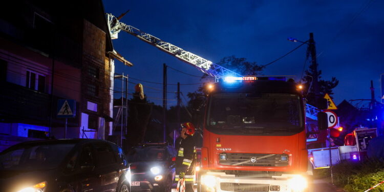 23.07.2022. Kraków. Strażacy zabezpieczają uszkodzony w wyniku gwałtownej nawałnicy dach budynku na obrzeżach Krakowa. Fot. Łukasz Gągulski - PAP