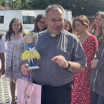 29.07.2022. Sandomierz. Koloniści z Kijowa w Sandomierzu. Na zdjęciu z lalką ks Bogusław Pitucha -dyrektor Caritas Diecezji Sandomierskiej. / Fot. Grażyna Szlęzak - Radio Kielce