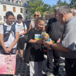 29.07.2022. Sandomierz. Koloniści z Kijowa w Sandomierzu. Na zdjęciu z lalką ks Bogusław Pitucha -dyrektor Caritas Diecezji Sandomierskiej. / Fot. Grażyna Szlęzak - Radio Kielce