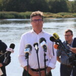 11.08.2022. Cigacice (woj. lubuskie). Podsekretarz stanu w Ministerstwie Infrastruktury Grzegorz Witkowski (z lewej) i prezes Państwowego Gospodarstwa Wodnego Wody Polskie Przemysław Daca (w środku) na konferencji prasowej we wsi Cigacice. Spotkanie dotyczyło zanieczyszczenia Odry / Fot. Lech Muszyński - PAP