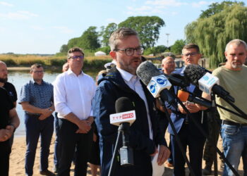 11.08.2022. Cigacice (woj. lubuskie). Podsekretarz stanu w Ministerstwie Infrastruktury Grzegorz Witkowski (w środku) i prezes Państwowego Gospodarstwa Wodnego Wody Polskie Przemysław Daca (z lewej) na konferencji prasowej we wsi Cigacice. Spotkanie dotyczyło zanieczyszczenia Odry / Fot. Lech Muszyński - PAP