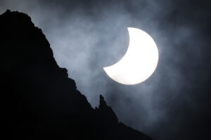 25.10.2022. Morskie Oko. Częściowe, ale głębokie zaćmienie Słońca, obserwowane nad Mięguszowieckimi Szczytami nad Morskim Okiem w Tatrach. Naturalny satelita Ziemi przykrywa od 32 do ponad 46 proc. powierzchni tarczy Słońca / Fot. Grzegorz Momot - PAP