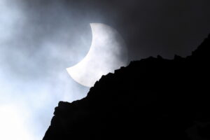 25.10.2022. Morskie Oko. Częściowe, ale głębokie zaćmienie Słońca, obserwowane nad Mięguszowieckimi Szczytami nad Morskim Okiem w Tatrach. Naturalny satelita Ziemi przykrywa od 32 do ponad 46 proc. powierzchni tarczy Słońca / Fot. Grzegorz Momot - PAP