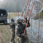 02.11.2022. Żerdziny. Budowa tymczasowej zapory na granicy z obwodem kaliningradzkim w okolicach miejscowości Żerdziny w gminie Dubeninki. / Fot. Tomasz Waszczuk - PAP