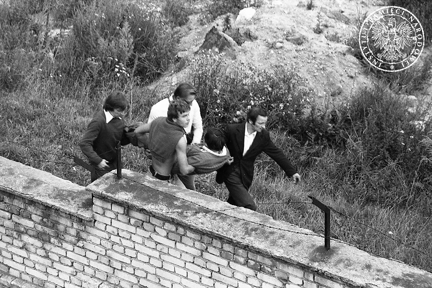 Mężczyźni niosący poszkodowanego podczas zamieszek w Gdańsku, prawdopodobnie w 1982 r. w rocznicę podpisania porozumień sierpniowych