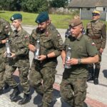 10.08.2023. Mokrsko Dolne. Delegacja 58. Marszu Szlakiem Pierwszej Kompanii Kadrowej złożyła wieńce i zapaliła znicze przed pamiątkową tablicą wmurowaną w kościelny mur / Fot. Krzysztof Bujnowicz - Radio Kielce