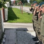 10.08.2023. Mokrsko Dolne. Delegacja 58. Marszu Szlakiem Pierwszej Kompanii Kadrowej złożyła wieńce i zapaliła znicze przed pamiątkową tablicą wmurowaną w kościelny mur / Fot. Krzysztof Bujnowicz - Radio Kielce