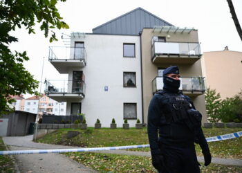 20.102.203. Gdynia. Funkcjonariusz policji przed blokiem mieszkalnym na Fikakowie w Gdyni, w którym znaleziono ciało 6-letniego dziecka. Na miejscu zbrodni pracują policjanci z wydziału dochodzeniowo-śledczego Komendy Wojewódzkiej Policji w Gdańsku, Komendy Miejskiej Policji w Gdyni oraz z Laboratorium Kryminalistycznego KWP w Gdańsku / Fot. Adam Warżawa - PAP