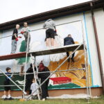 26.09.2024. Masłów. Uczniowie pod okiem artysty Mikołaja Korusa malują mural przedstawiający poetę Jana Kochanowskiego na budynku Szkoły Podstawowej w Brzezinkach / Fot. Wiktor Taszłow - Radio Kielce