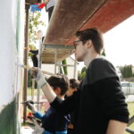 26.09.2024. Masłów. Uczniowie pod okiem artysty Mikołaja Korusa malują mural przedstawiający poetę Jana Kochanowskiego na budynku Szkoły Podstawowej w Brzezinkach / Fot. Wiktor Taszłow - Radio Kielce