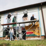 26.09.2024. Masłów. Uczniowie pod okiem artysty Mikołaja Korusa malują mural przedstawiający poetę Jana Kochanowskiego na budynku Szkoły Podstawowej w Brzezinkach / Fot. Wiktor Taszłow - Radio Kielce