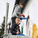 26.09.2024. Masłów. Uczniowie pod okiem artysty Mikołaja Korusa malują mural przedstawiający poetę Jana Kochanowskiego na budynku Szkoły Podstawowej w Brzezinkach / Fot. Wiktor Taszłow - Radio Kielce