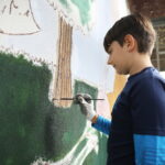 26.09.2024. Masłów. Uczniowie pod okiem artysty Mikołaja Korusa malują mural przedstawiający poetę Jana Kochanowskiego na budynku Szkoły Podstawowej w Brzezinkach / Fot. Wiktor Taszłow - Radio Kielce