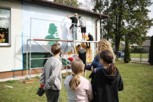 26.09.2024. Masłów. Uczniowie pod okiem artysty Mikołaja Korusa malują mural przedstawiający poetę Jana Kochanowskiego na budynku Szkoły Podstawowej w Brzezinkach / Fot. Wiktor Taszłow - Radio Kielce