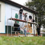 26.09.2024. Masłów. Uczniowie pod okiem artysty Mikołaja Korusa malują mural przedstawiający poetę Jana Kochanowskiego na budynku Szkoły Podstawowej w Brzezinkach / Fot. Wiktor Taszłow - Radio Kielce