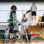 26.09.2024. Masłów. Uczniowie pod okiem artysty Mikołaja Korusa malują mural przedstawiający poetę Jana Kochanowskiego na budynku Szkoły Podstawowej w Brzezinkach / Fot. Wiktor Taszłow - Radio Kielce