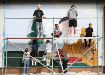 26.09.2024. Masłów. Uczniowie pod okiem artysty Mikołaja Korusa malują mural przedstawiający poetę Jana Kochanowskiego na budynku Szkoły Podstawowej w Brzezinkach / Fot. Wiktor Taszłow - Radio Kielce