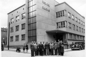 Grupa dziennikarzy ze Szwecji zwiedzających nowo zbudowany gmach Radia Katowiece. W tle samochód osobowy i motocykl. 1937 rok / źródło: Narodowe Archiwum Cyfrowe