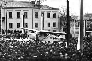 14.11.1937. Kielce. Plac Najświętszej Marii Panny. Uczestnicy uroczystości poświęcenia samolotu sanitarnego ufundowanego przez duchowieństwo diecezji kieleckiej przed budynkiem plebanii / źródło: Narodowe Archiwum Cyfrowe