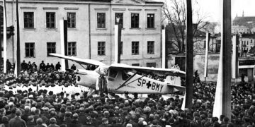 14.11.1937. Kielce. Plac Najświętszej Marii Panny. Uczestnicy uroczystości poświęcenia samolotu sanitarnego ufundowanego przez duchowieństwo diecezji kieleckiej przed budynkiem plebanii / źródło: Narodowe Archiwum Cyfrowe