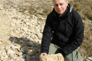 Piotr Szrek podczas poszukiwań skamieniałości w Kopcu / Fot. G. Gierliński; źródło: Państwowy Instytut Geologiczny - Państwowy Instytut Badawczy; grafika Jakub Zalewski